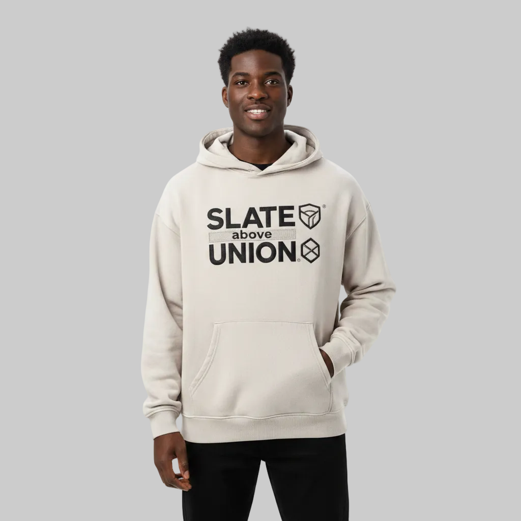 A light beige hoodie with a black graphic print on the chest reading 'SLATE above UNION' alongside geometric cube icons, displayed on a clean white background.